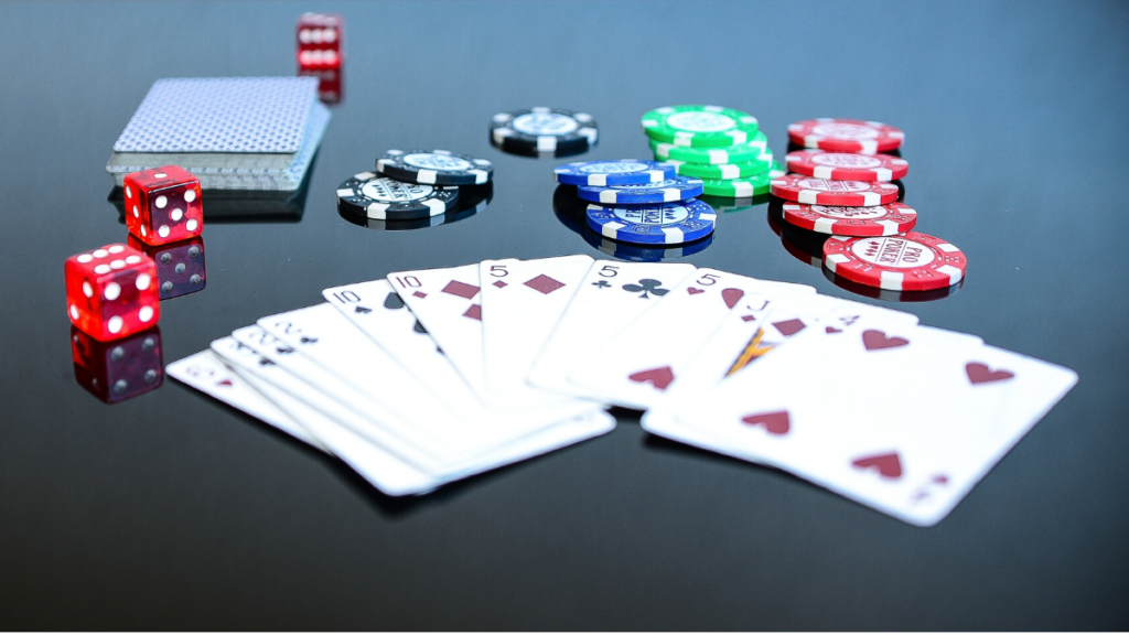 A picture of fanned out cards withpoker chips and dice behind them