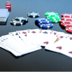 A picture of fanned out cards withpoker chips and dice behind them